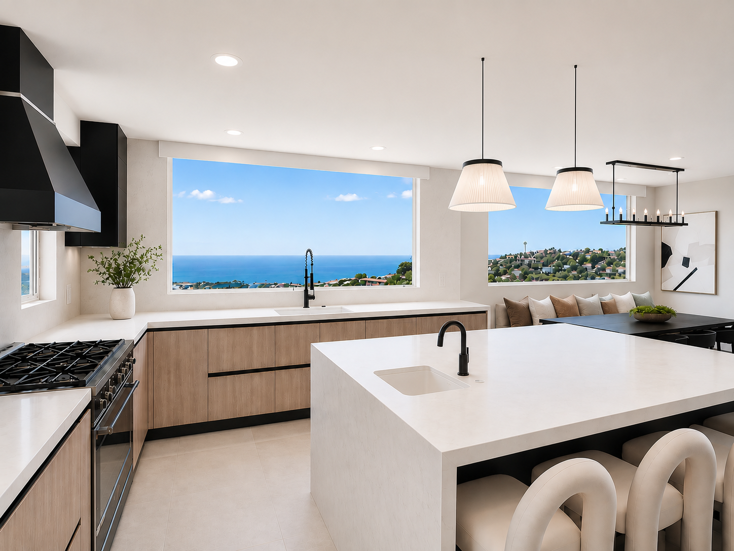 Kitchen with white quartz island, warm wood cabinetry, black pendants, and panoramic ocean views through picture windows